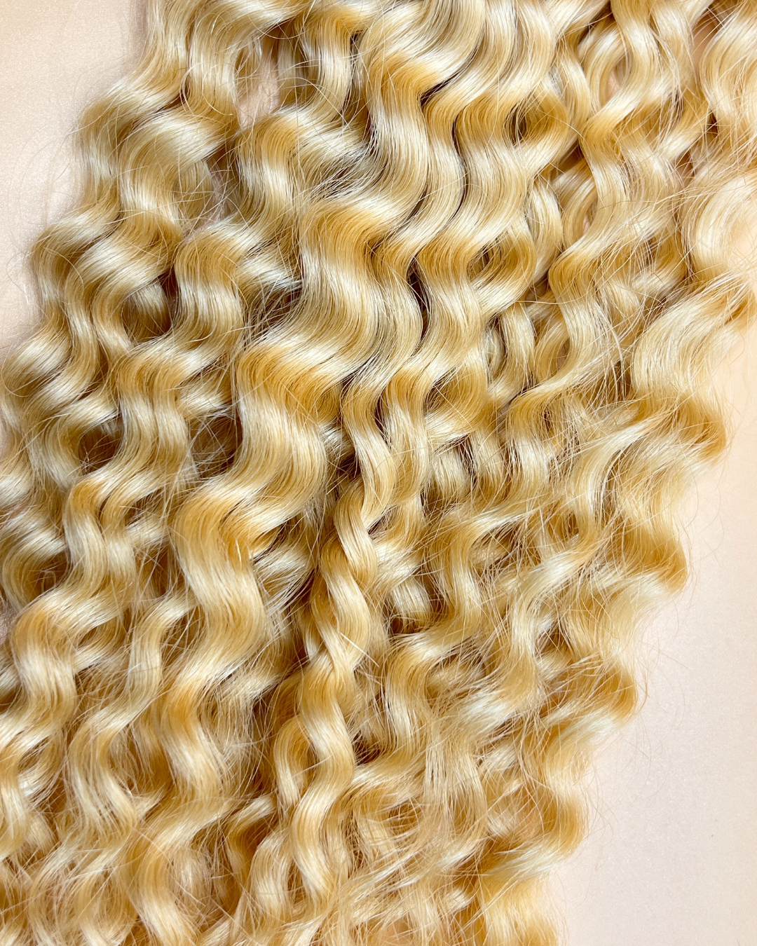 Extensions de couleurs blond chaud avec l'étiquette de la marque olimahair et une matière bouclé 