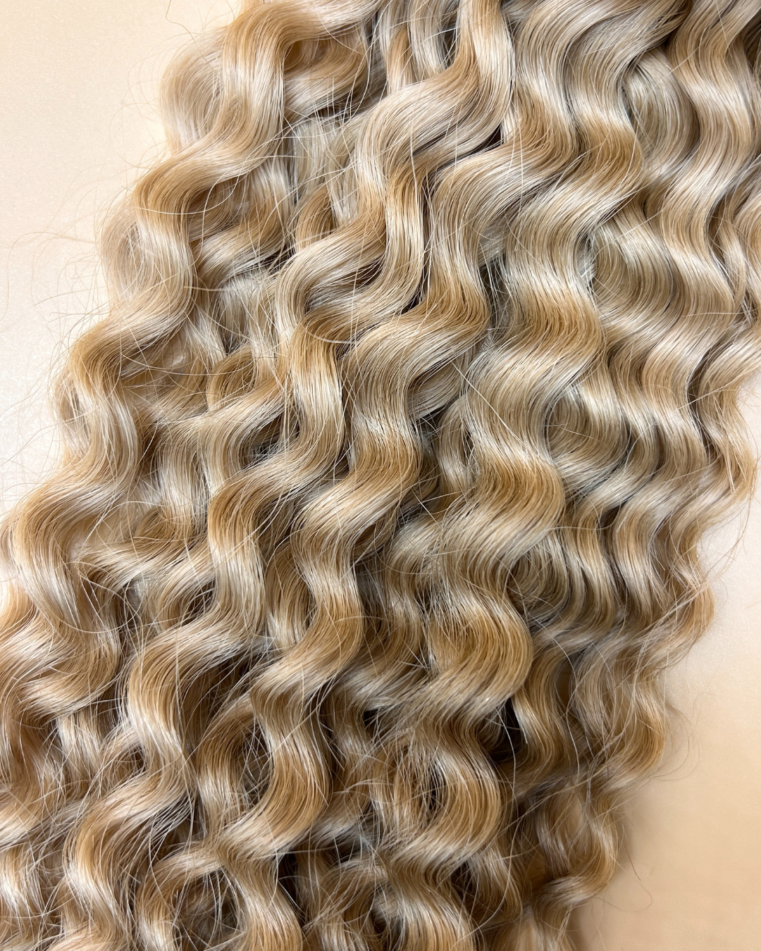 Extensions de couleurs blond froid avec l'étiquette de la marque olimahair et une matière bouclé 
